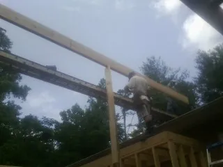 Carpenter setting a ridge beam over a new addition frame — Ice Dam Removal by Roofing Brothers in Fe Warren Afb