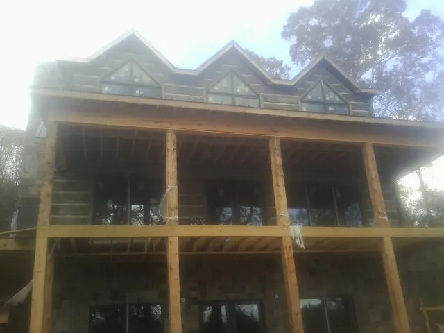 Dormers and porch framing on a large log home under construction — Roof Coating work by our crew in Fe Warren Afb