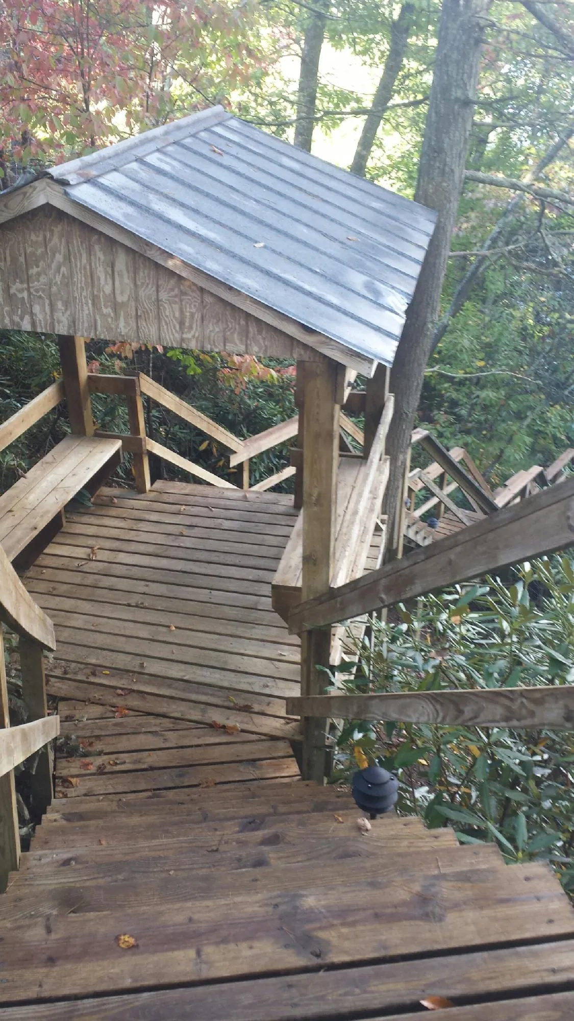 Metal roofed shelter over wooden steps on a wooded walkway — Skylight Repair & Installation work by our crew in Fe Warren Afb